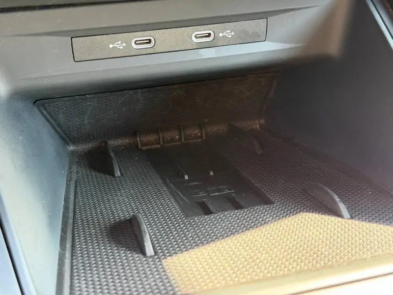 Gros plan sur la zone de recharge sans fil et ports USB-C du coffre à gants d'une CUPRA Formentor Noir Minuit métallisé 2025.