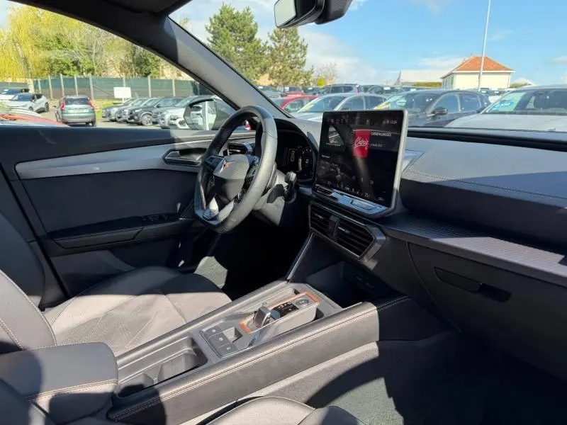 Intérieur de la CUPRA Formentor 1.5 eTSI Hybrid 2025 vu côté conducteur, avec tableau de bord moderne et écran tactile central.