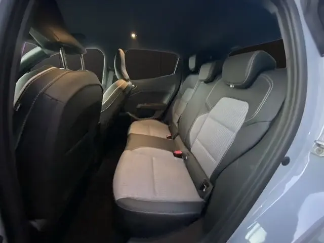 Vue intérieure arrière droite de la Renault Clio gris clair 2025, montrant la banquette 3 places bi-matière avec appuie-têtes.