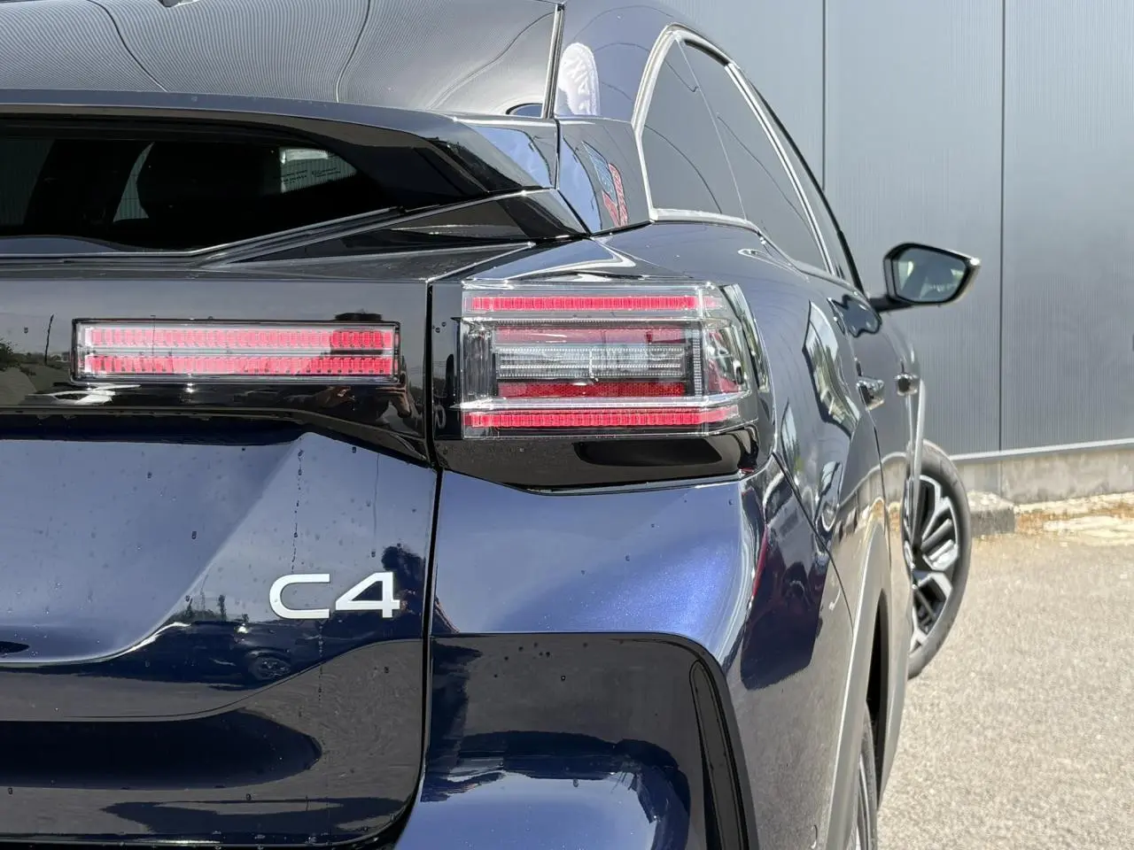 Vue arrière droite du Citroën C4 Hybrid 2025 en Bleu Eclipse avec feux arrière LED et jantes alliage 18 pouces.