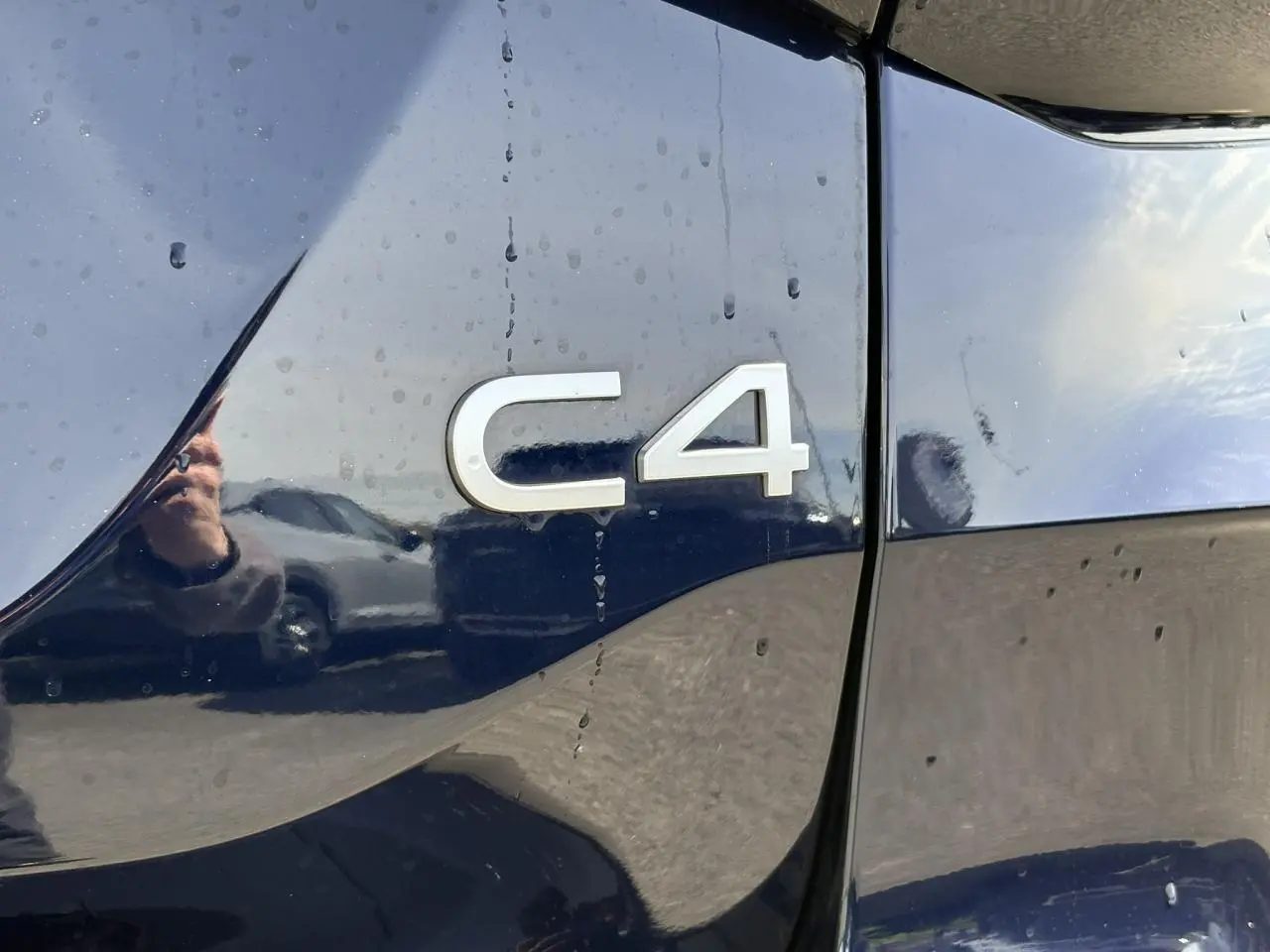 Gros plan sur l’inscription C4 sur la carrosserie bleu Eclipse brillante d’une Citroën C4.