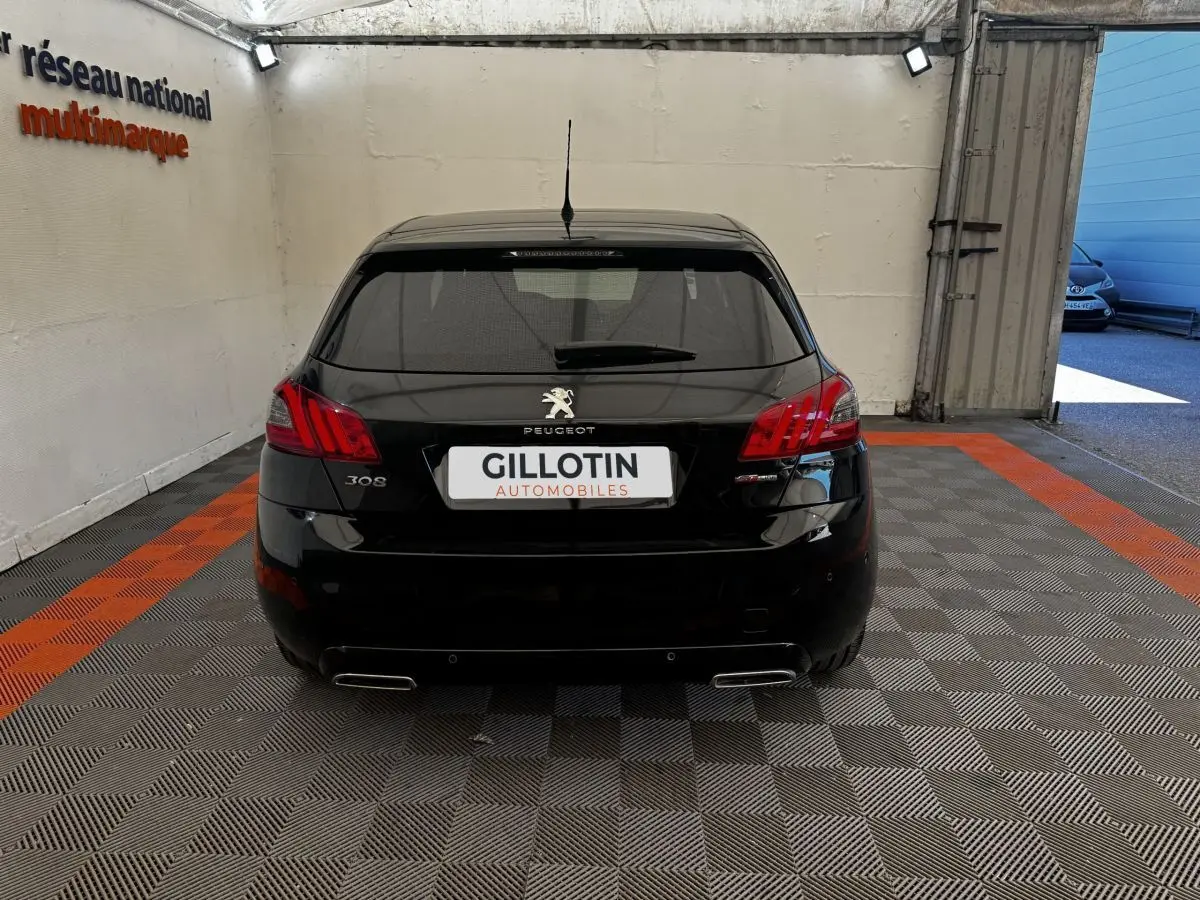 Vue arrière d'une Peugeot 308 noire GT Line 2018, avec feux rouges et double sortie d'échappement chromée visible.