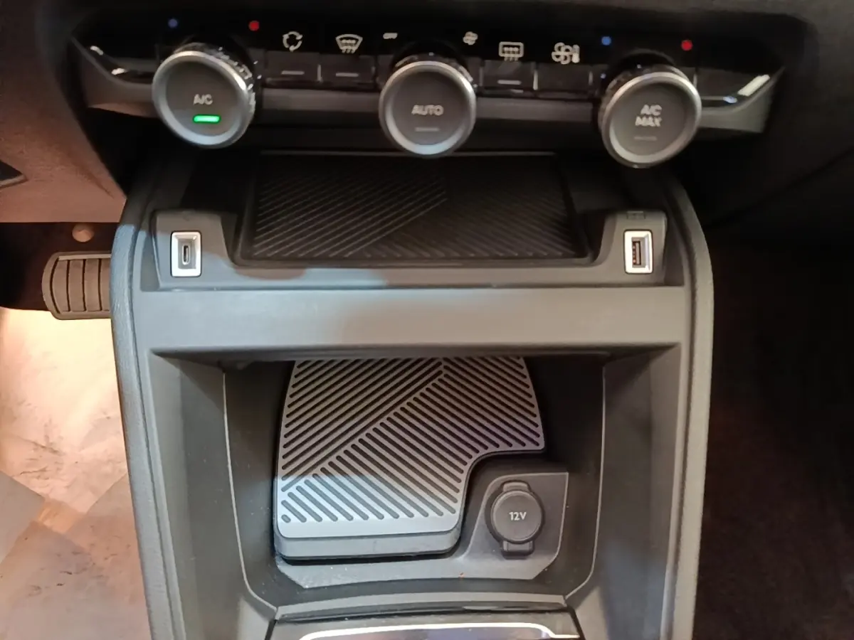 Gros plan sur la console centrale du Citroën C4 X 2023, montrant les commandes de climatisation et prises USB et 12V.
