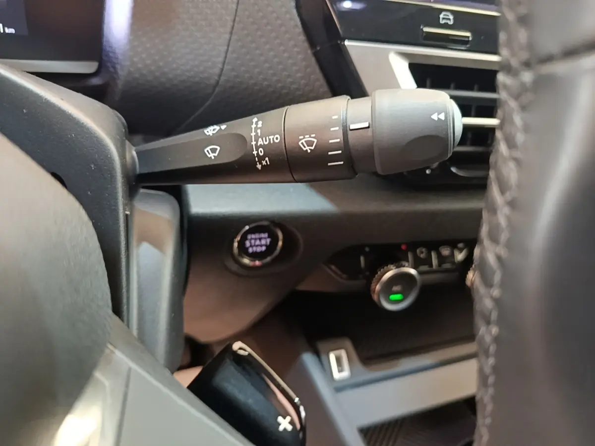Gros plan sur la commande d’essuie-glace et le bouton démarrage du tableau de bord intérieur noir du Citroën C4 X.