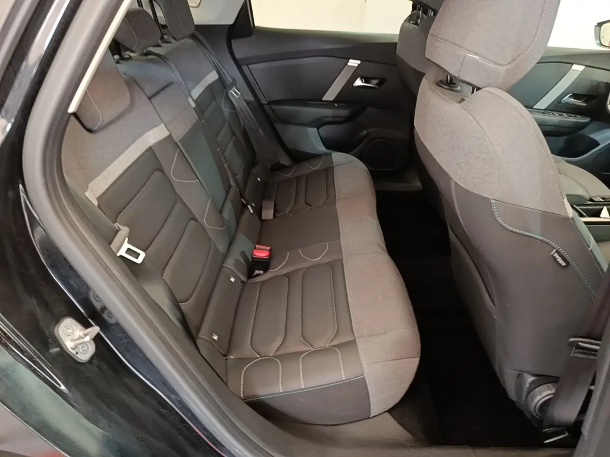 Vue intérieure côté gauche sur la banquette arrière bi-matière grise et noire du Citroën C4 X noir 2023.