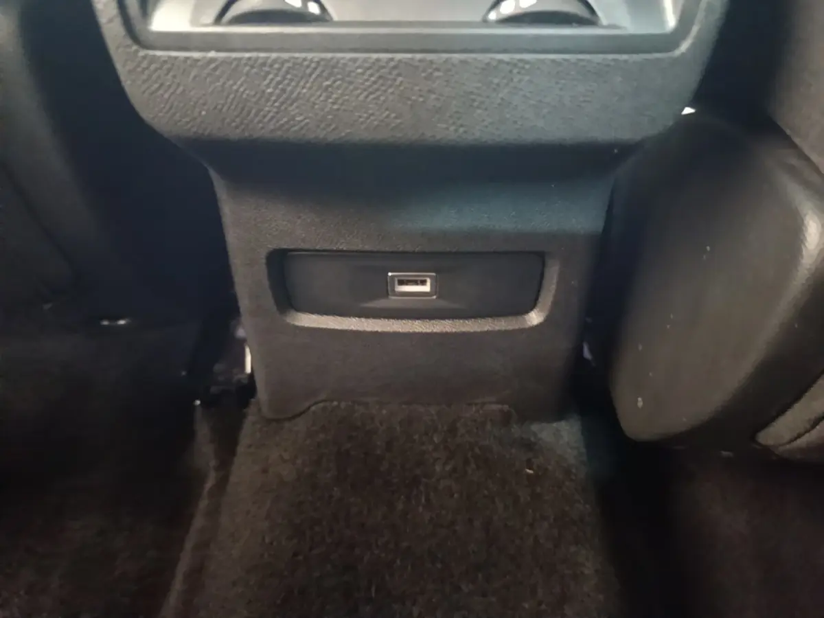 Prise USB noire vue en gros plan sur la console arrière du Citroën C4 X PureTech 130 Shine 2023.