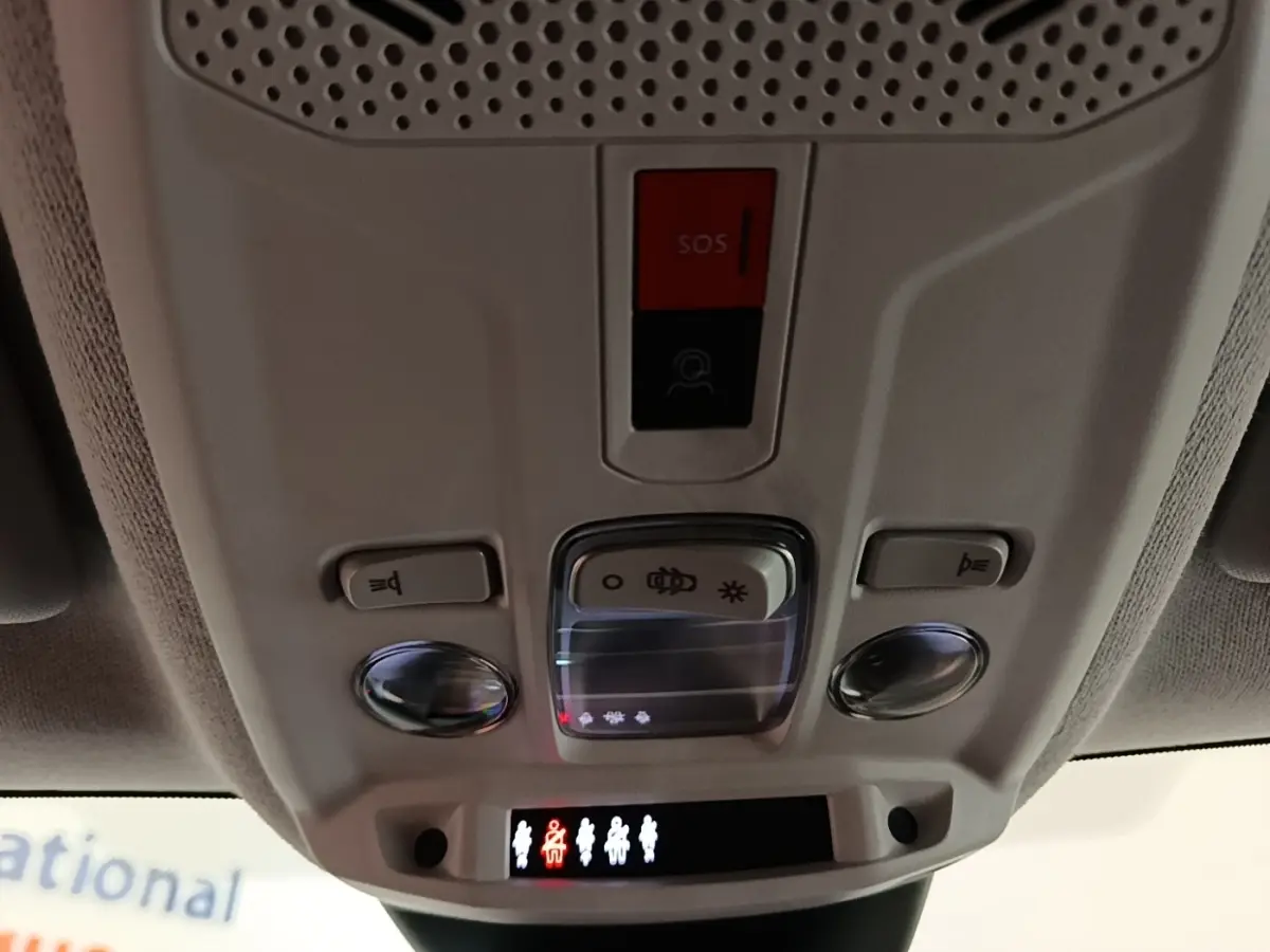 Vue intérieure du plafonnier gris clair avec boutons SOS et éclairage dans une Citroën C4 X noire de 2023.