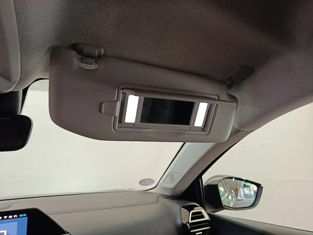 Détail intérieur du pare-soleil avec miroir éclairé côté conducteur de la Citroën C4 X noire, vue avant droite.