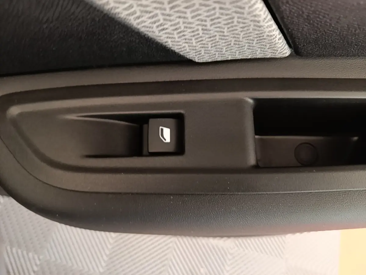 Gros plan sur le bouton de commande de la vitre électrique côté intérieur d'une porte de Citroën C4 X noire.