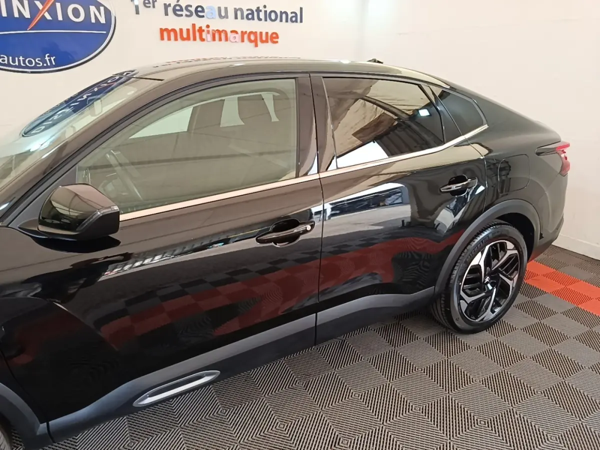 Profil droit d'une Citroën C4 X noire 2023 avec jantes alliage et lignes de toit fluides.