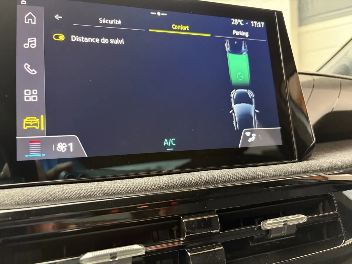 Vue rapprochée de l'écran tactile central de la Renault Clio blanche 2026, affichant les réglages de confort et sécurité.