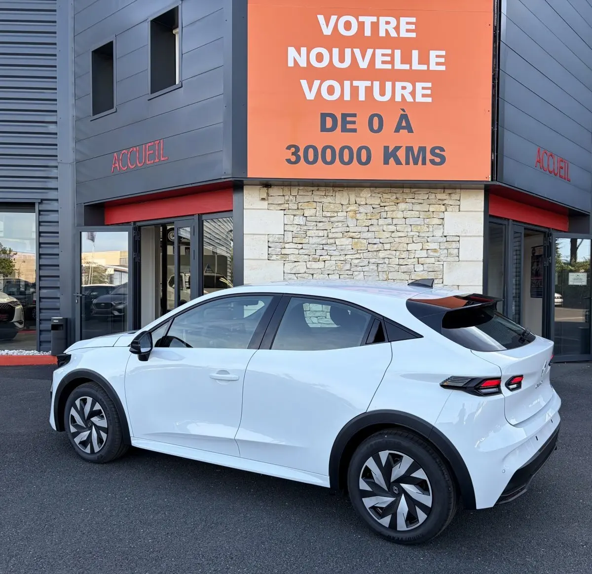 Renault Clio Evolution TCe 115 blanc vue côté gauche en 3/4 arrière, avec feux arrière LED et toit noir contrasté.