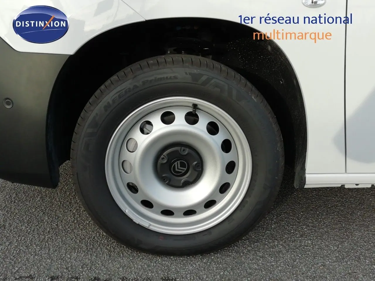 Gros plan sur la roue avant droite d’un Citroën Berlingo XL blanc Icy avec jante acier et logo Citroën central.