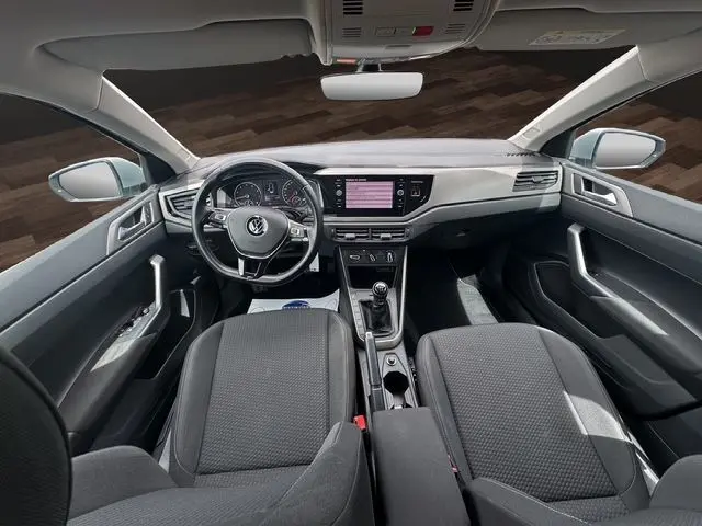 Intérieur gris de la Volkswagen Polo VI Lounge Business 2021 vu de face, avec tableau de bord et volant multifonction.
