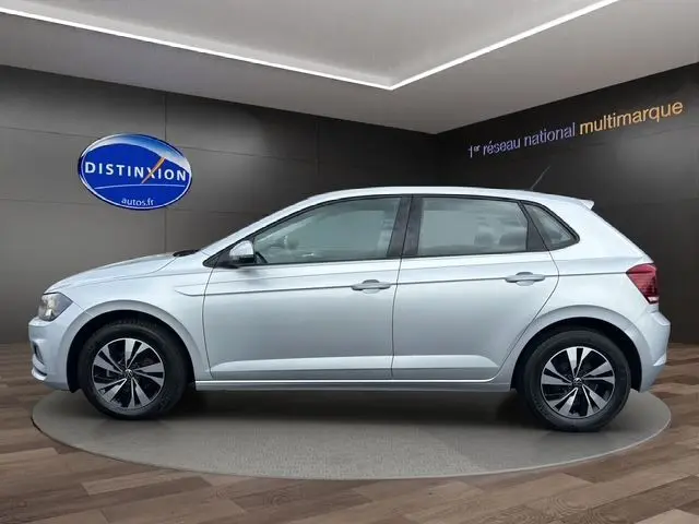 Profil côté gauche d'une Volkswagen Polo VI Lounge Business gris clair, avec jantes alliage et intérieur tissu noir visible.