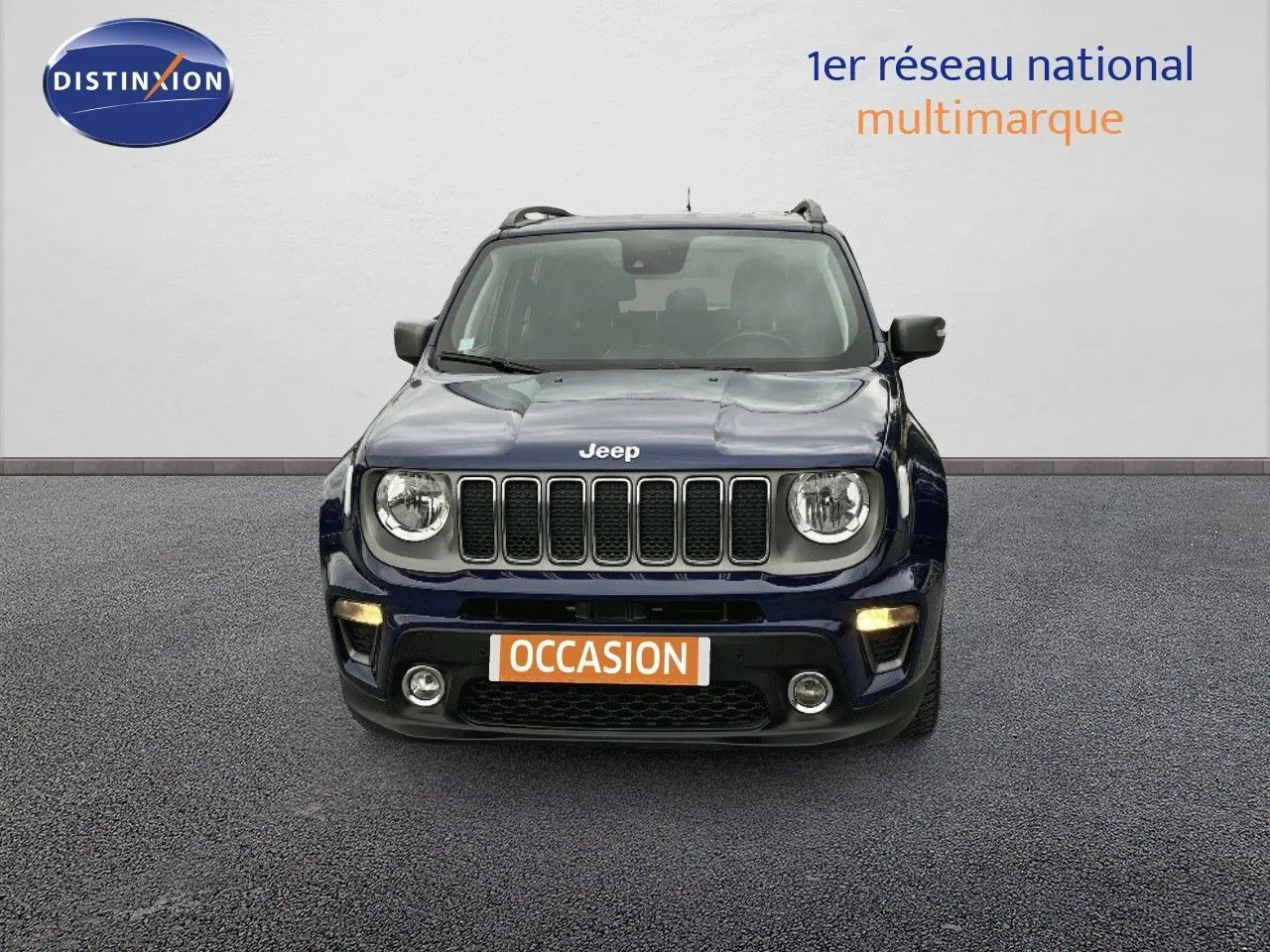 Vue frontale d'un Jeep Renegade bleu 2020 avec calandre à sept fentes et phares ronds allumés.