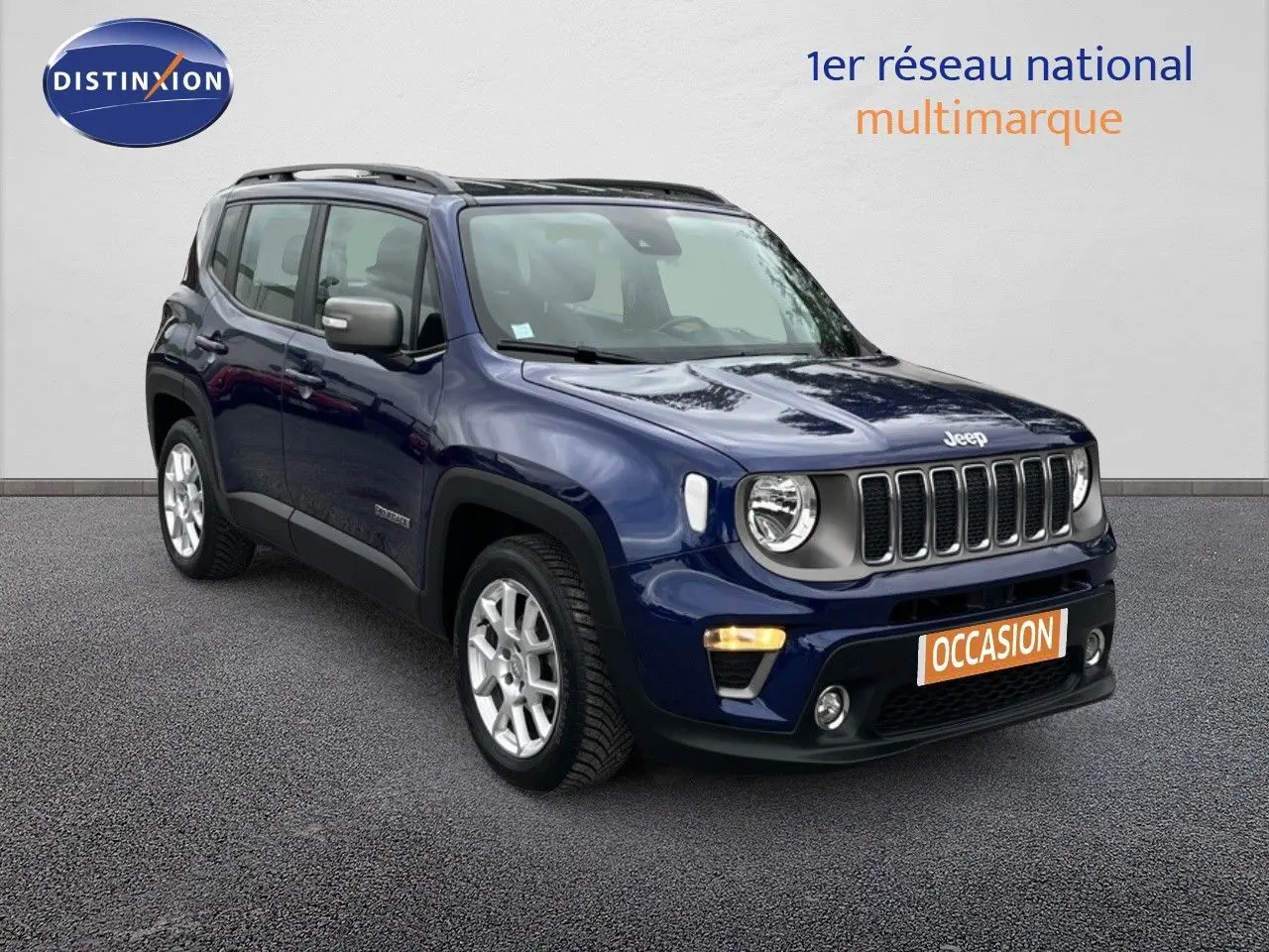 Jeep Renegade bleu en 3/4 avant droit avec calandre distinctive et feux ronds allumés sur fond neutre.