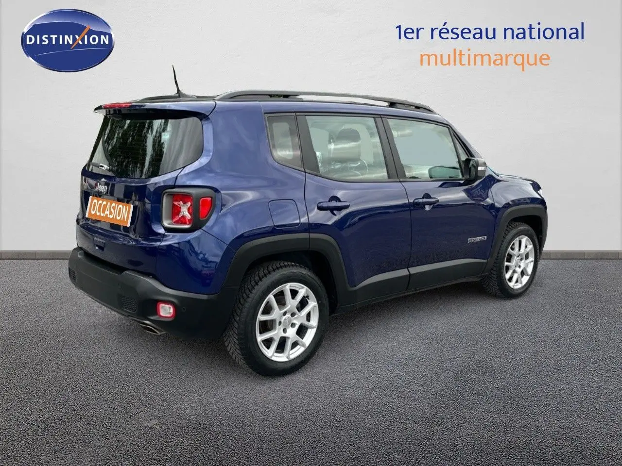 Jeep Renegade bleu vue 3/4 arrière côté droit, avec jantes argentées et toit ouvrant visible.