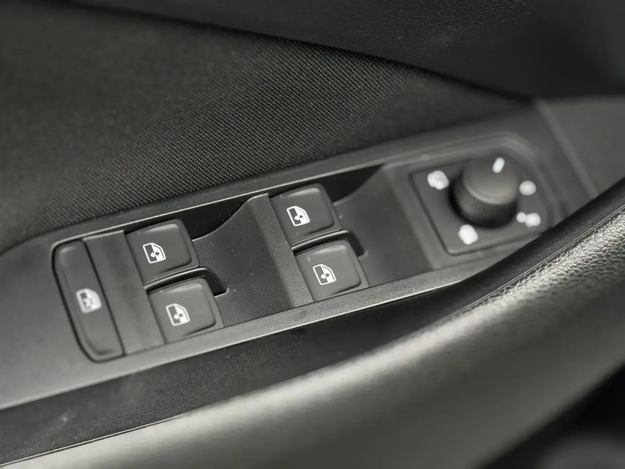 Gros plan sur les commandes des vitres et rétroviseurs côté conducteur de la Skoda Kamiq gris argent 2025.