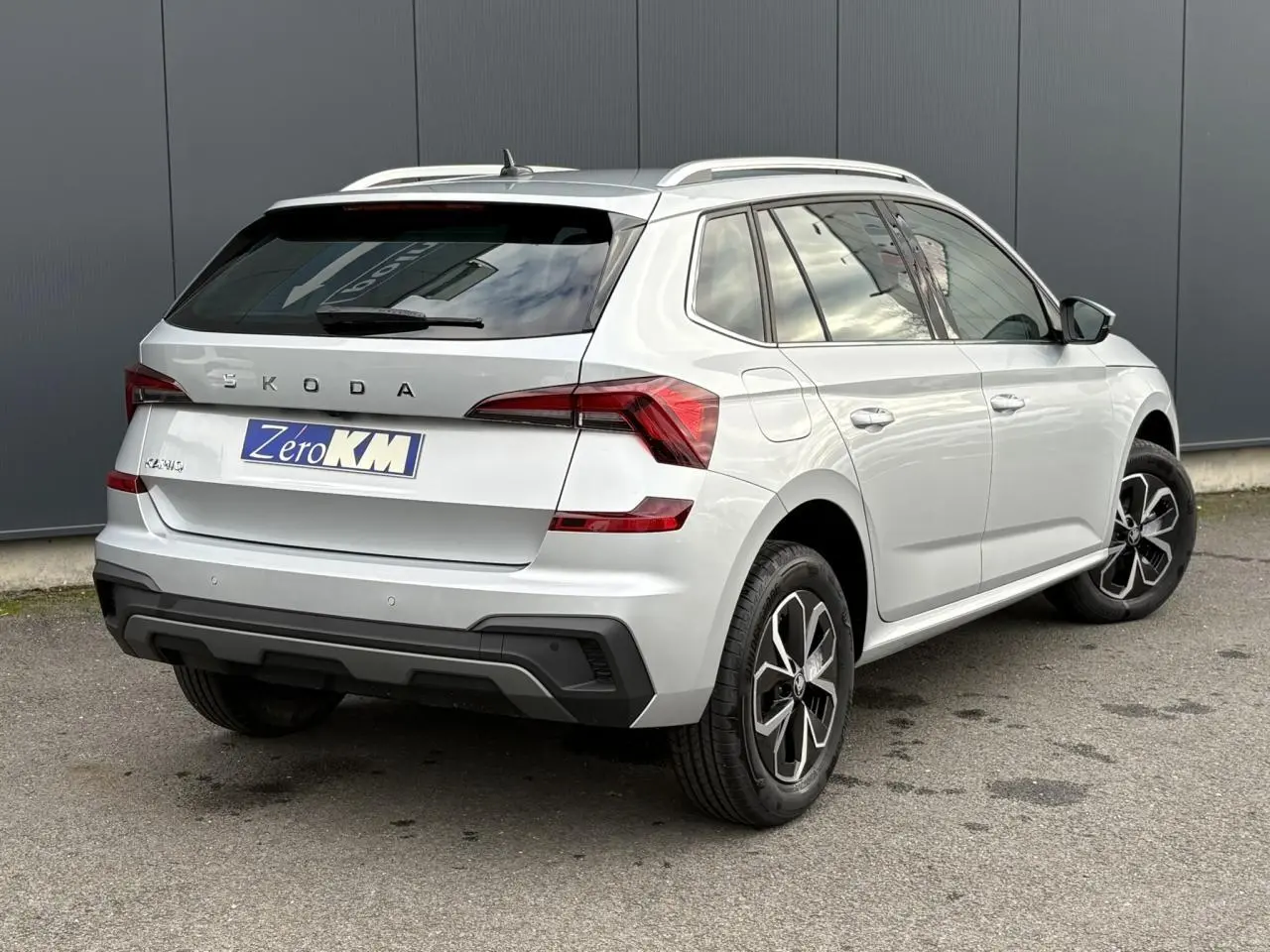 Vue 3/4 arrière droite du Skoda Kamiq gris argent avec vitres surteintées et jantes alliage noires.