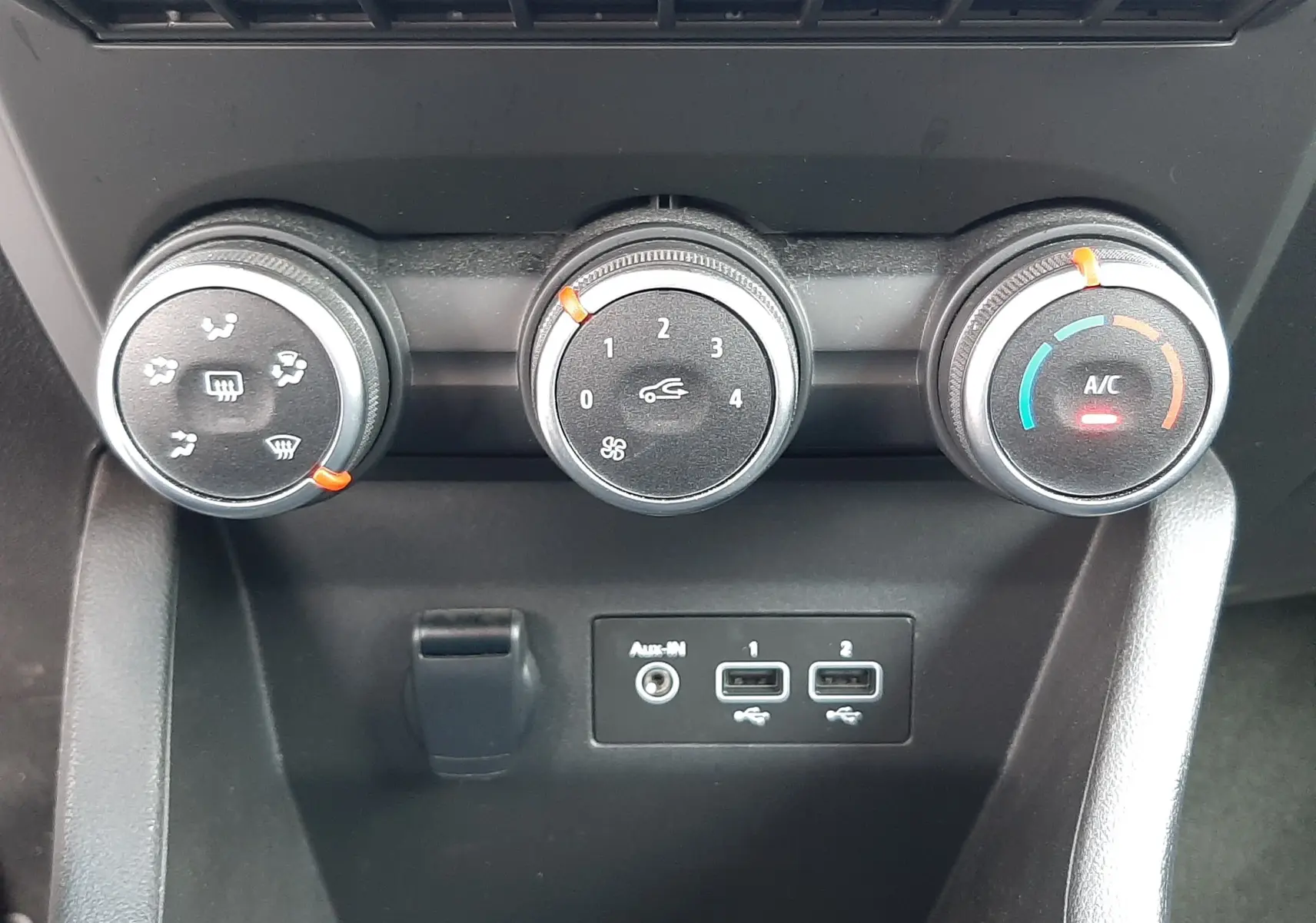 Gros plan sur les commandes de climatisation et les ports USB de la Renault Clio V blanche, version 1.0 TCE 90CH Équilibre.