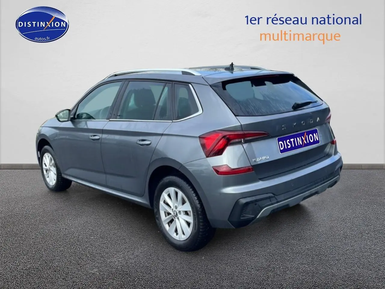 Vue 3/4 arrière droite d’un Skoda Kamiq gris 2025 avec barres de toit et feux arrière LED distinctifs.