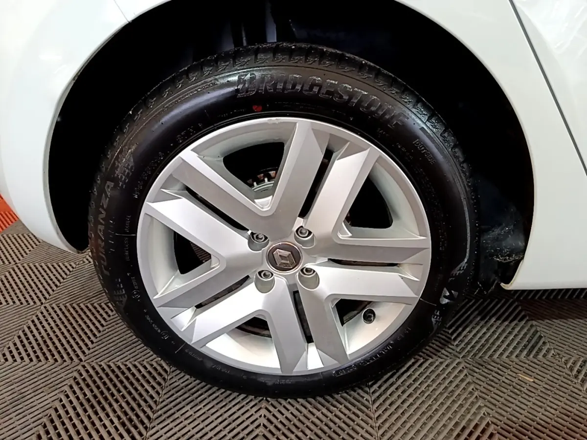 Gros plan sur la roue avant droite blanche d'une Renault Clio Business 2021 avec jante alliage et logo Renault central.