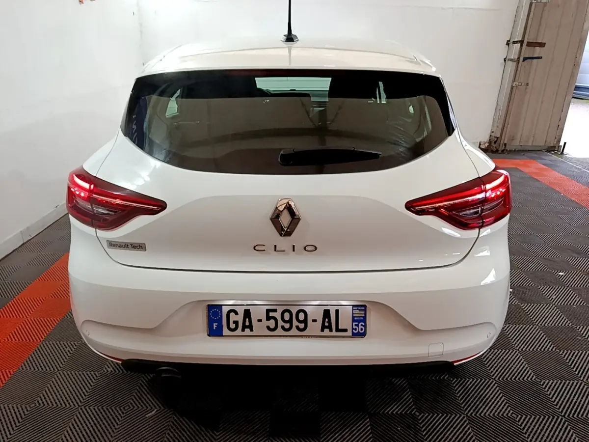 Vue arrière d'une Renault Clio blanche 2021 avec feux LED allumés dans un garage fermé.