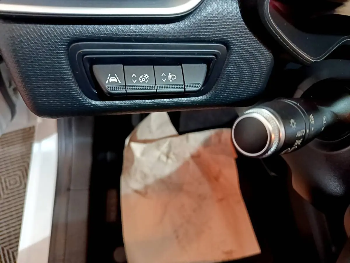 Détail intérieur côté gauche du tableau de bord de la Renault Clio Business blanche, avec commandes d’assistance à la conduite.