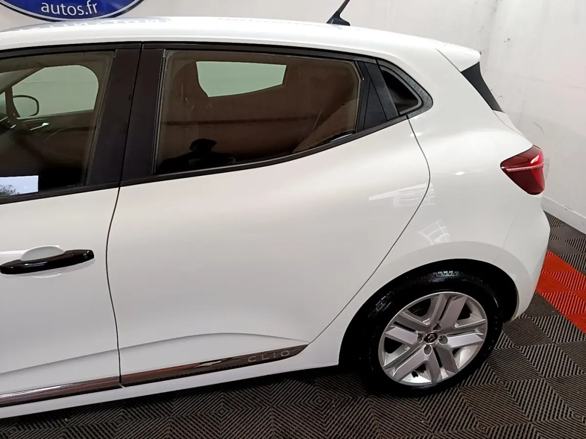 Vue côté droit arrière de la Renault Clio Business blanche, avec jante alliage et feux arrière LED visibles.