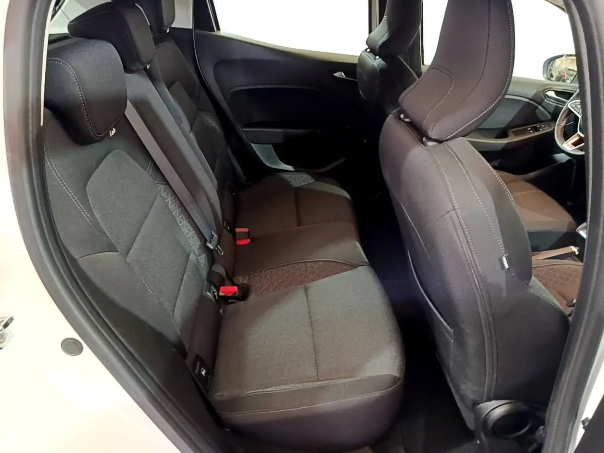 Vue intérieure côté droit montrant les sièges arrière noirs et le siège avant d'une Renault Clio Business blanche.
