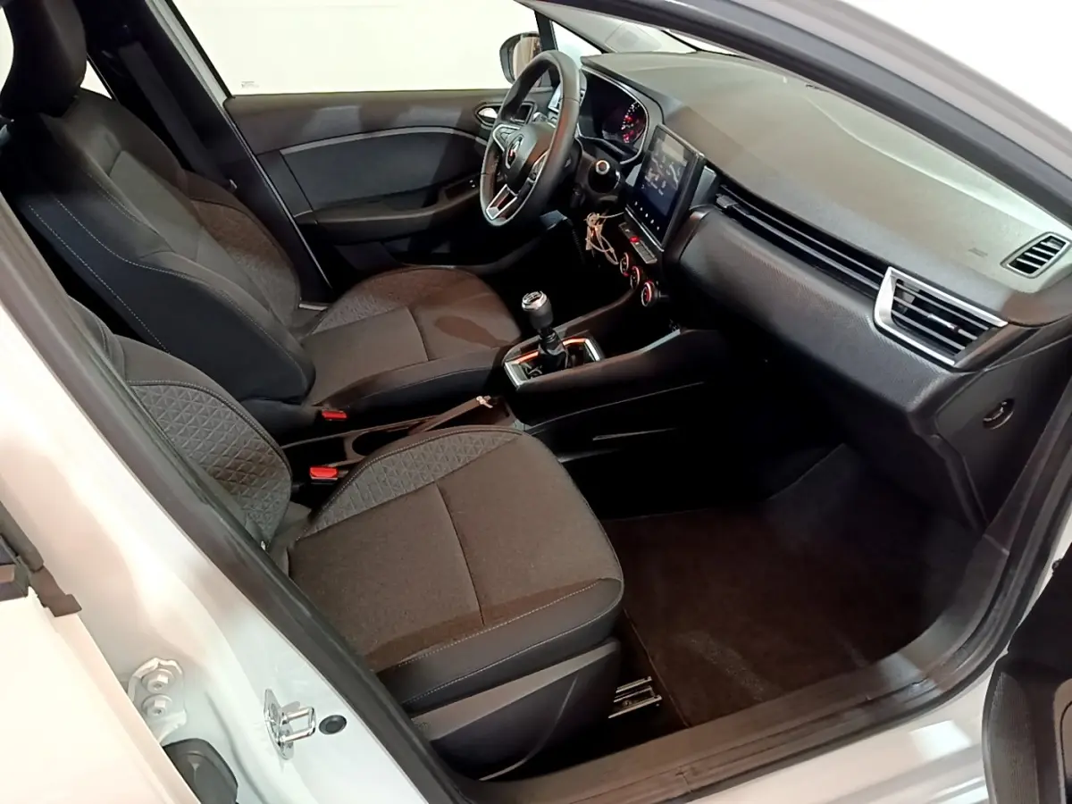 Intérieur de la Renault Clio Business blanc vue côté conducteur, montrant sièges tissu et tableau de bord avec écran tactile.