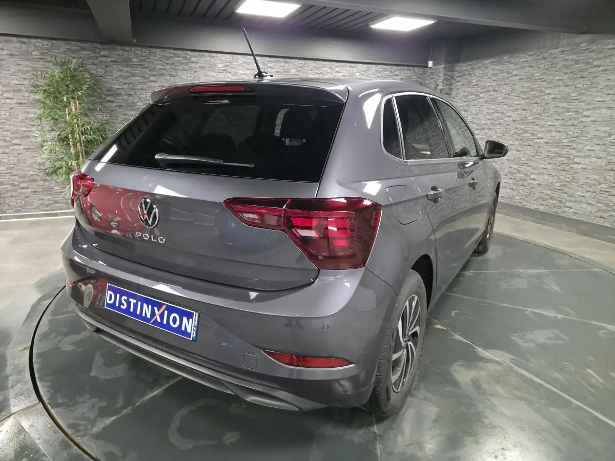 Volkswagen Polo gris métallisé vue 3/4 arrière droit avec jantes alliage et feux LED distinctifs.