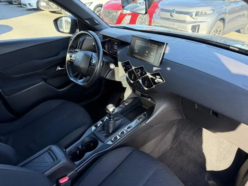 Vue intérieure côté conducteur du DS3 Crossback 2020, tableau de bord noir avec écran tactile et levier de vitesse manuel.