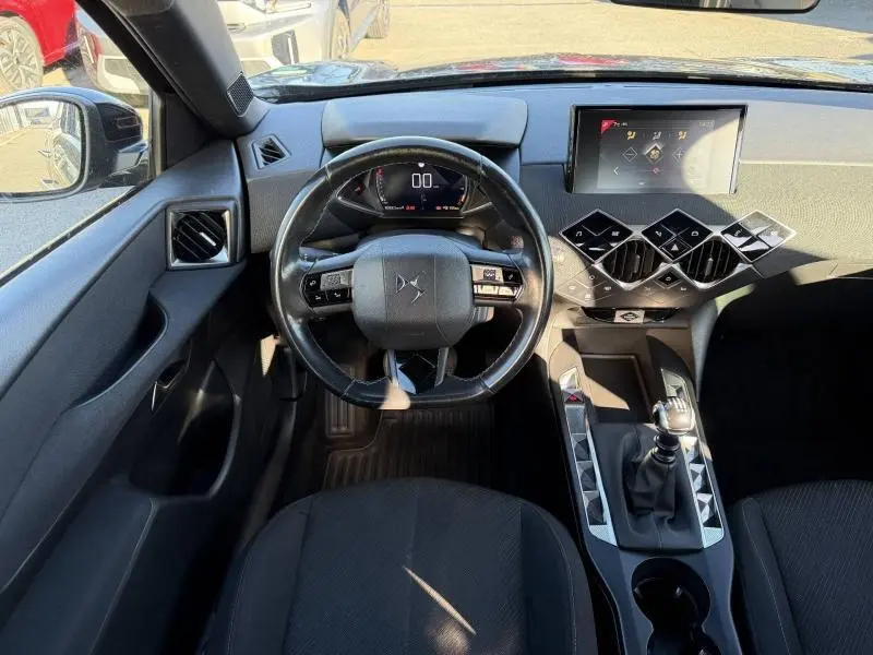 Vue intérieure centrée sur le volant et la console centrale du DS3 Crossback 2020, avec écran tactile et levier de vitesses manuel.