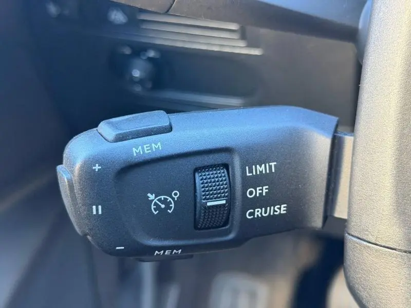 Gros plan sur la commande de régulateur de vitesse du DS3 Crossback PureTech 100ch Chic, intérieur noir.