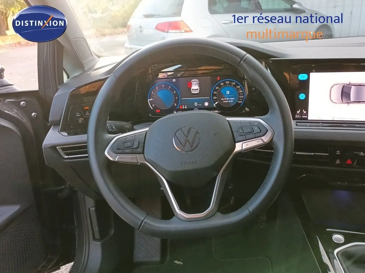 Vue intérieure centrée sur le volant et le tableau de bord numérique de la Volkswagen Golf 1.5 TSI gris Urano, année 2024.