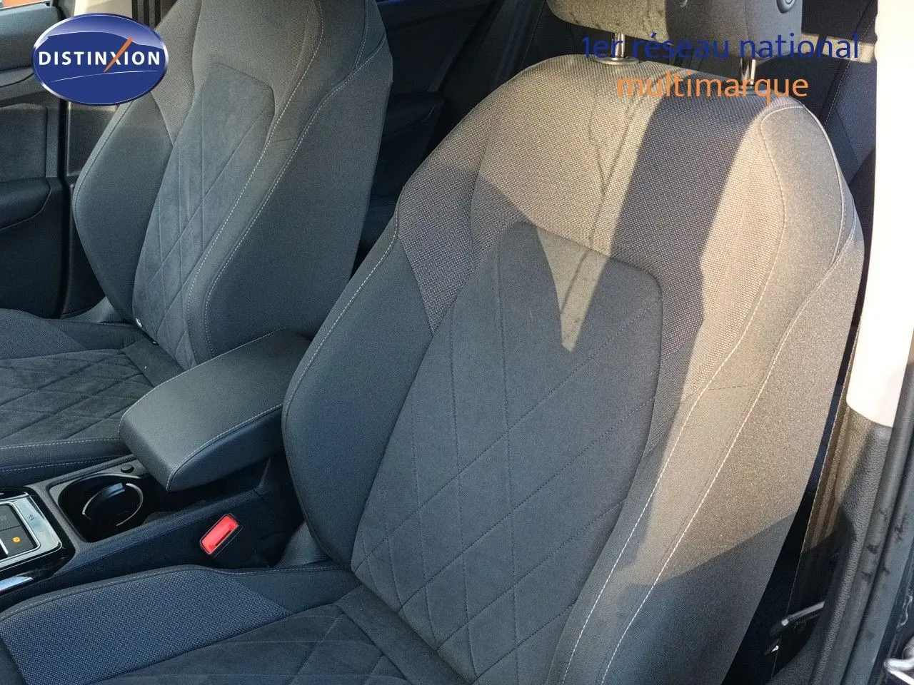 Gros plan sur les sièges avant gris noir de la Volkswagen Golf 1.5 TSI 130CH Style 2024, avec accoudoir central et coutures apparentes.
