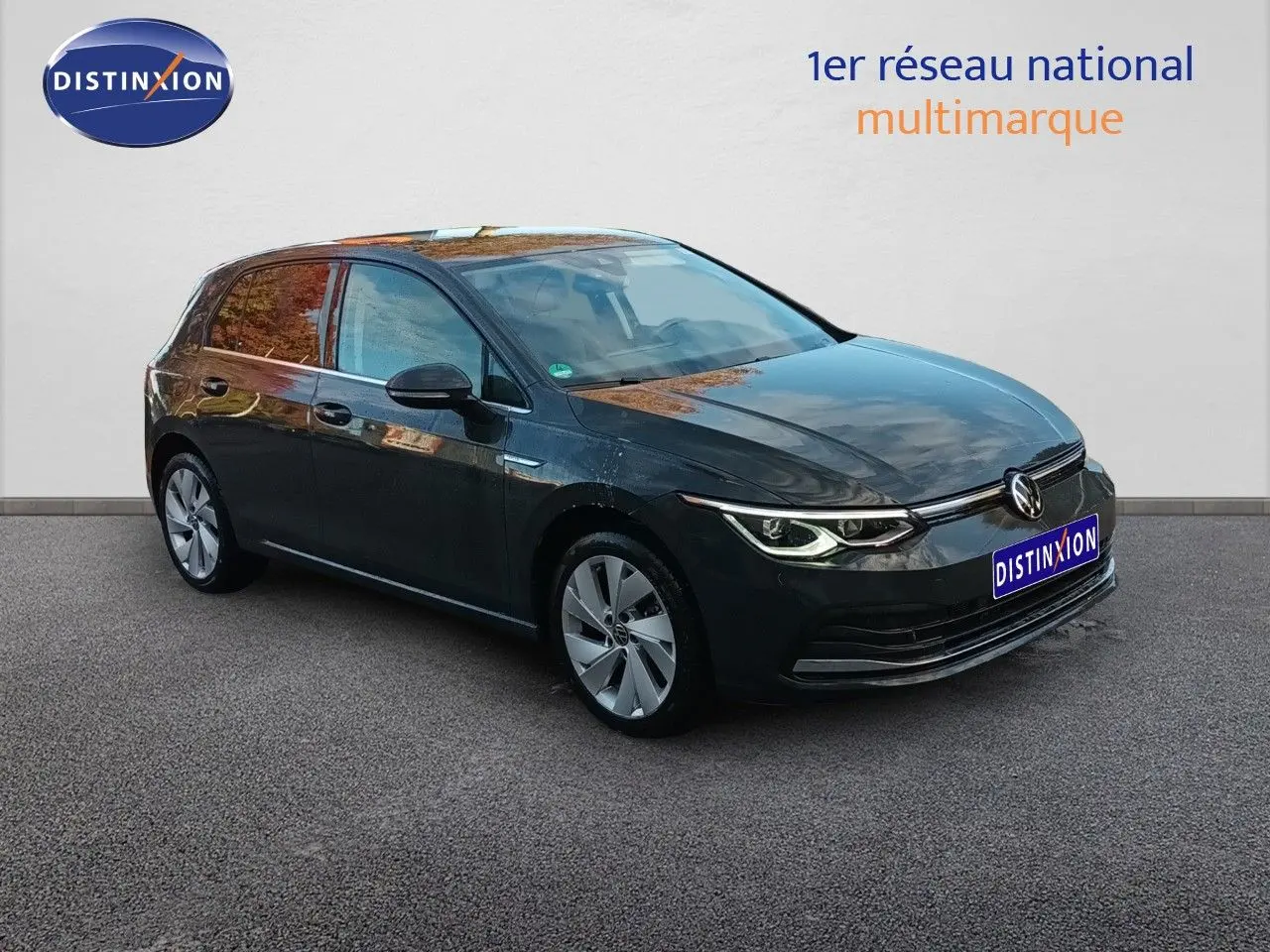 Volkswagen Golf 1.5 TSI 130ch Style gris Urano vue 3/4 avant droit avec phares LED allumés sur fond neutre.