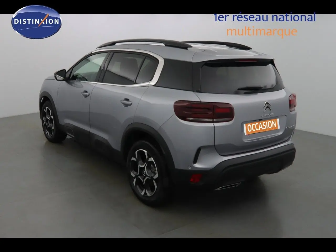 Vue frontale d'un Citroën C5 Aircross gris Artense métal avec calandre noire et plaques d'immatriculation bleues Zero KM.