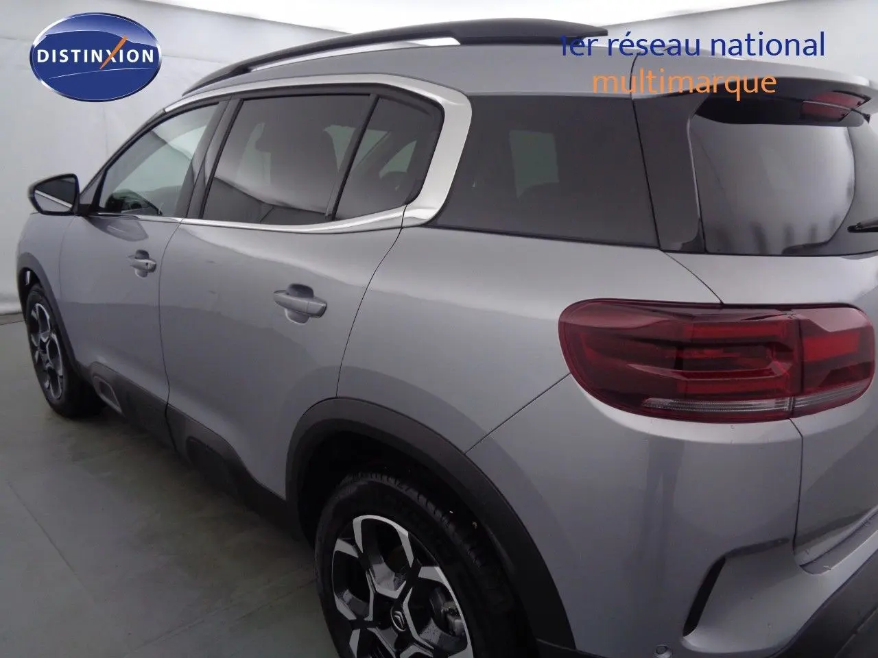 Profil côté gauche du Citroën C5 Aircross gris Artense métal avec jantes bi-ton et barres de toit noires.