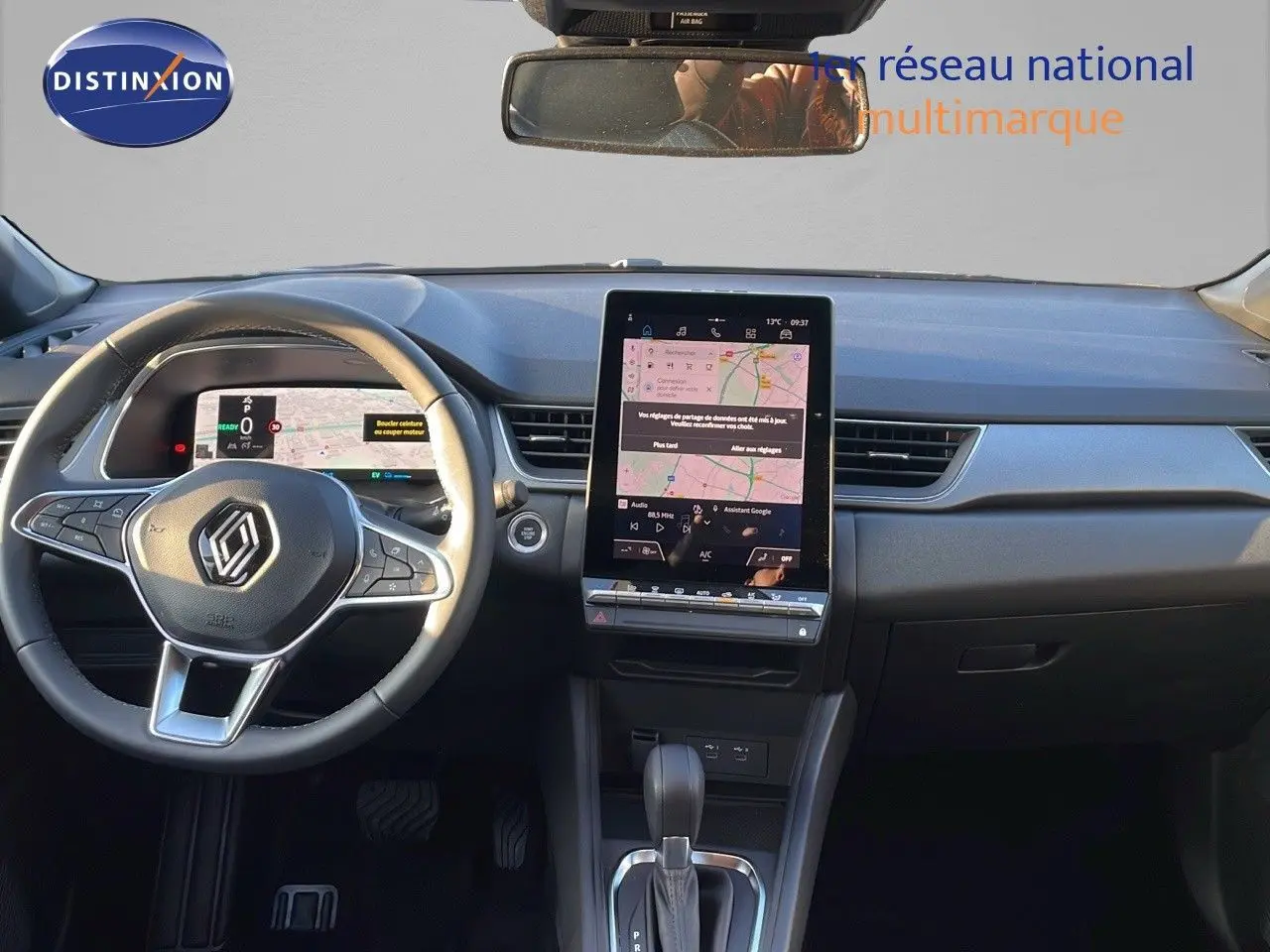 Intérieur du Renault Captur E-Tech 2025, vue frontale du tableau de bord avec écran tactile vertical et volant noir.