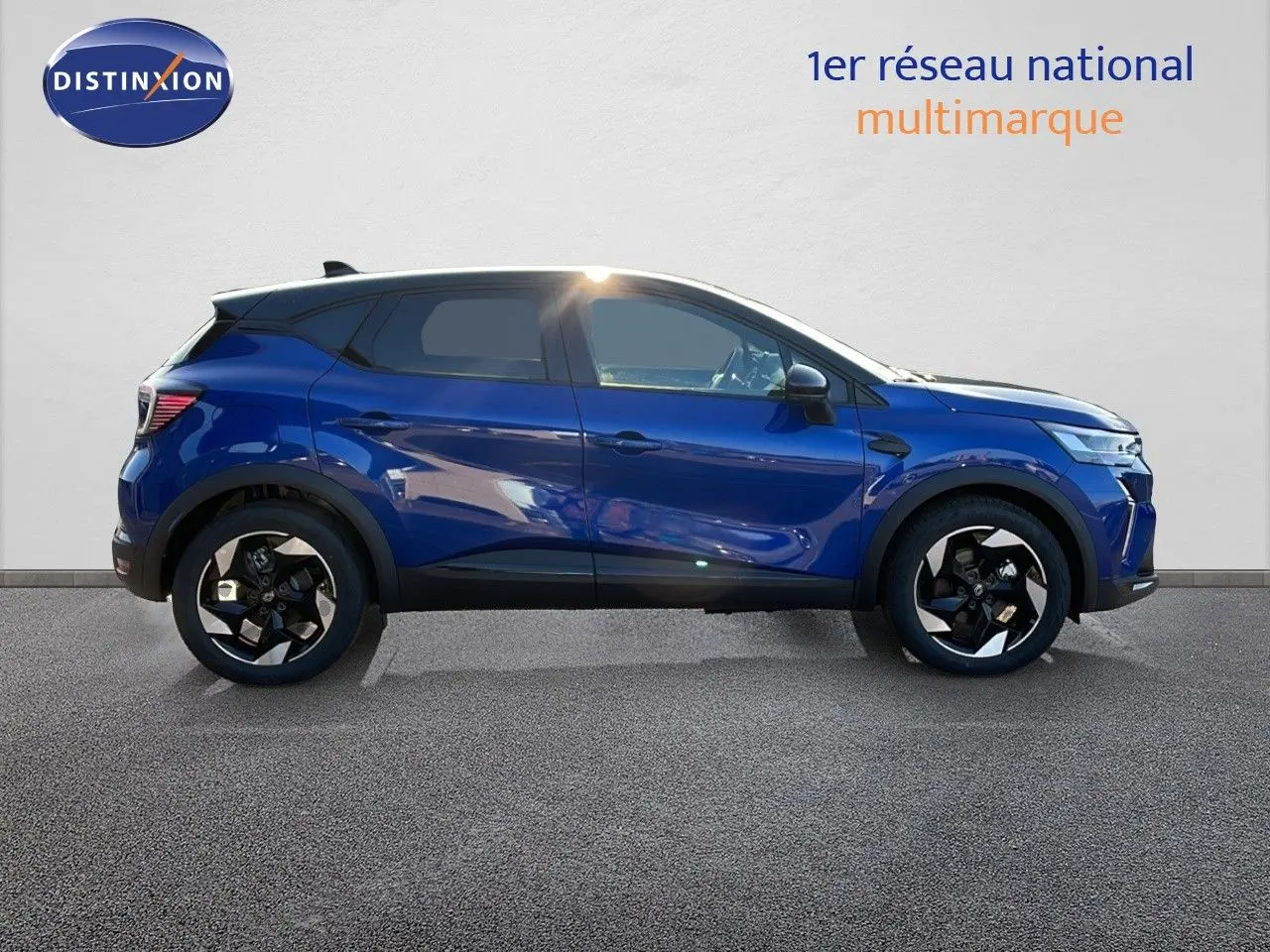 Profil droit du Renault Captur E-Tech hybride 2025 en bleu Iron Metal avec toit noir et jantes noires.