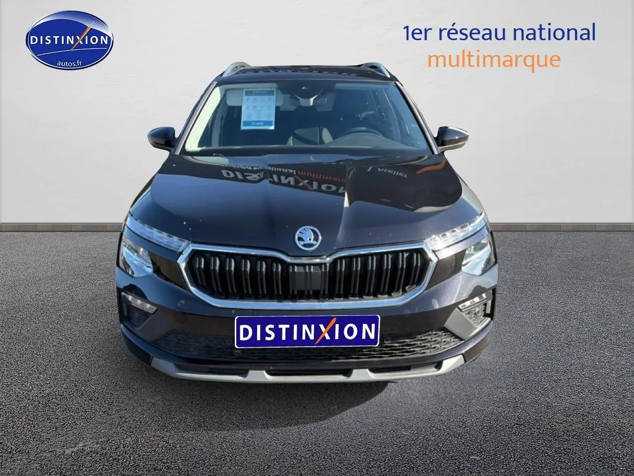 Vue avant d'un Skoda Kamiq noir 2025 avec calandre chromée et feux LED, sur fond neutre avec logo Distinxion.