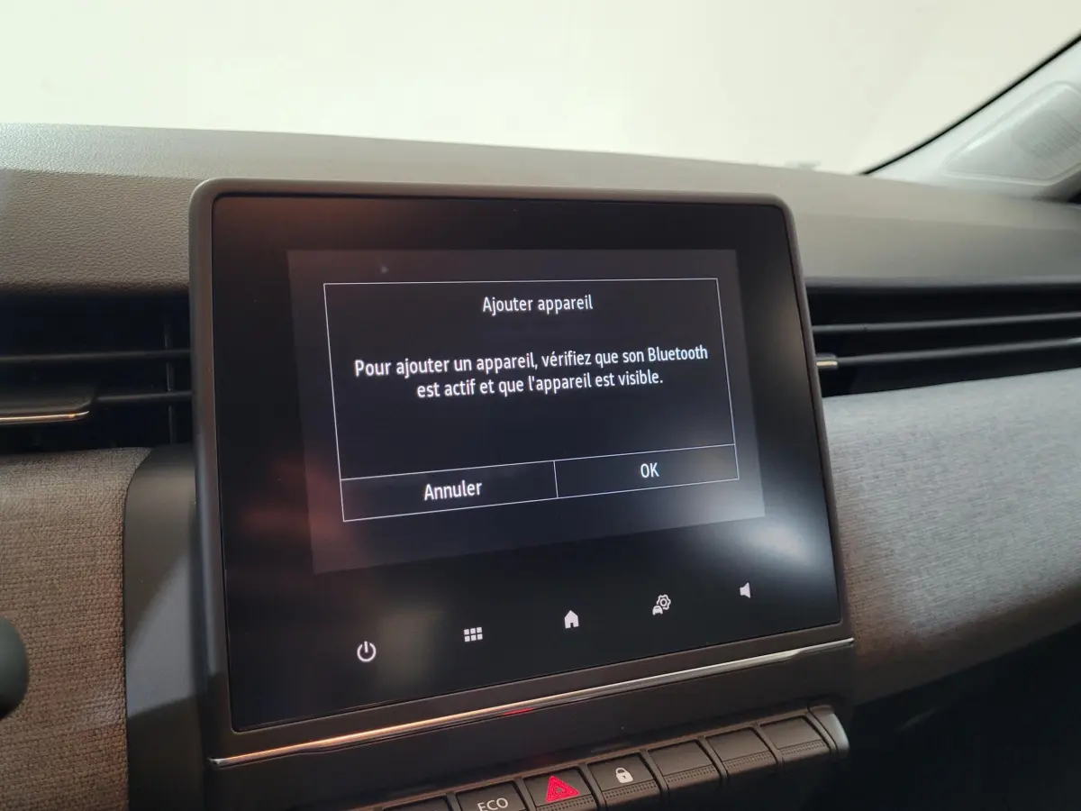 Écran tactile central du tableau de bord de la Renault Clio bleu 2025 affichant un message Bluetooth.