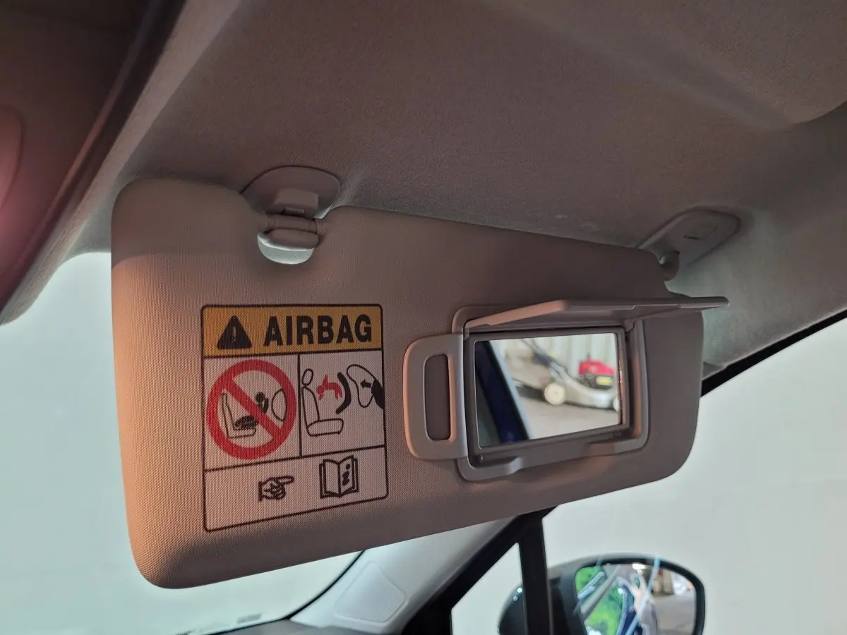 Détail du pare-soleil côté conducteur avec miroir intégré et avertissement airbag dans une Renault Clio bleu 2025.