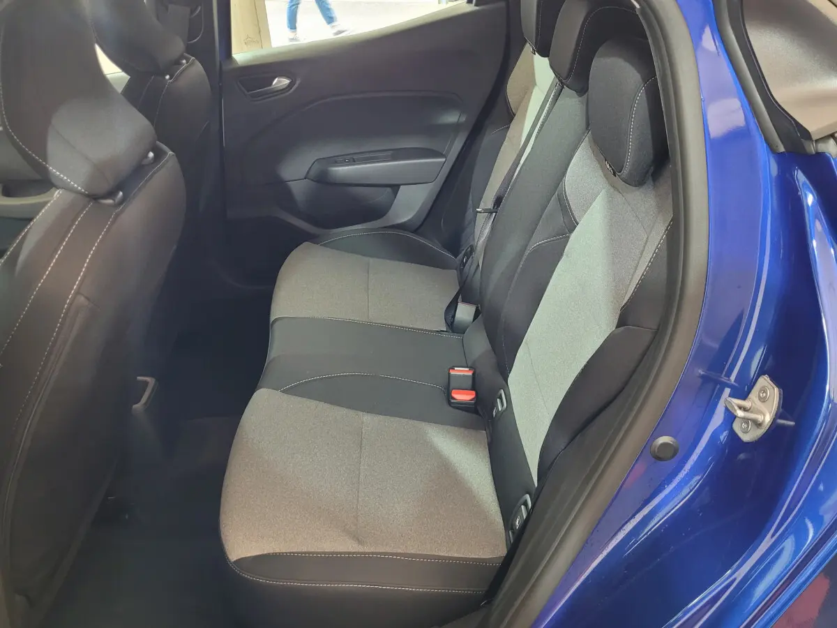 Vue côté droit de la banquette arrière grise et noire de la Renault Clio bleu 2025 avec porte ouverte.