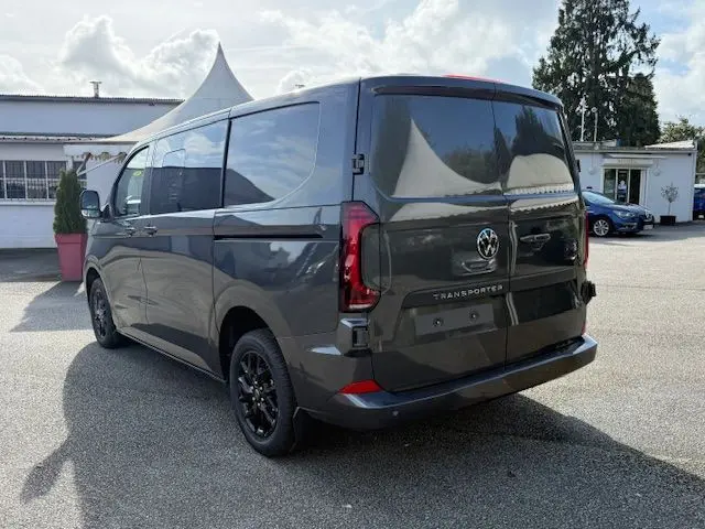 Vue 3/4 arrière droite du Volkswagen Transporter T7 ProCab Business gris graphite, avec jantes noires et feux LED distinctifs.