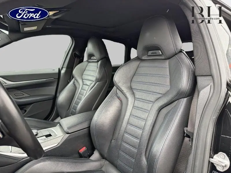 Vue intérieure côté conducteur de la BMW Série 4 Gran Coupe 420iA M Sport avec sièges cuir noir et surpiqûres bleues.