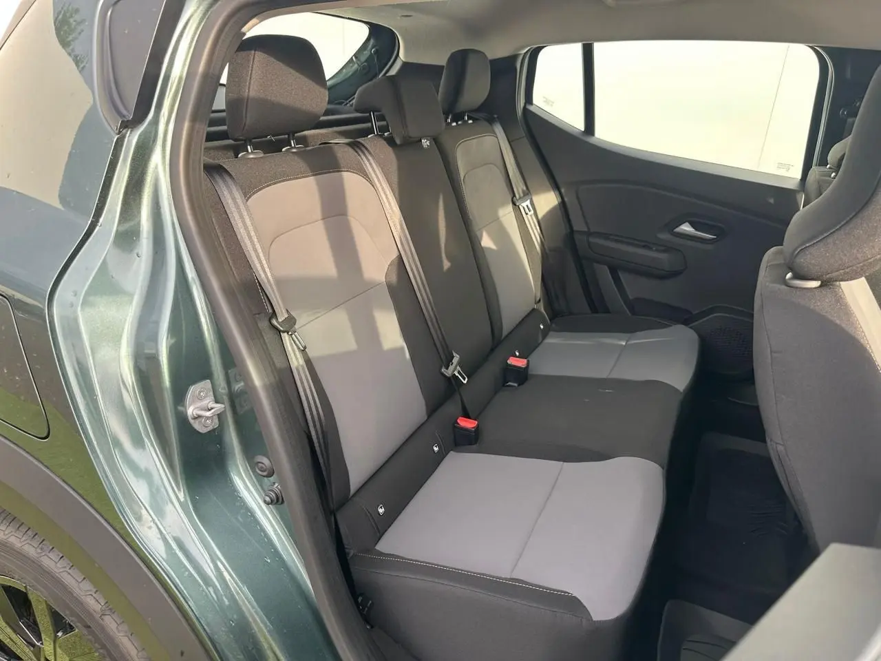 Vue intérieure arrière côté gauche de la banquette bicolore gris et noir du Dacia Sandero III Stepway vert cèdre.